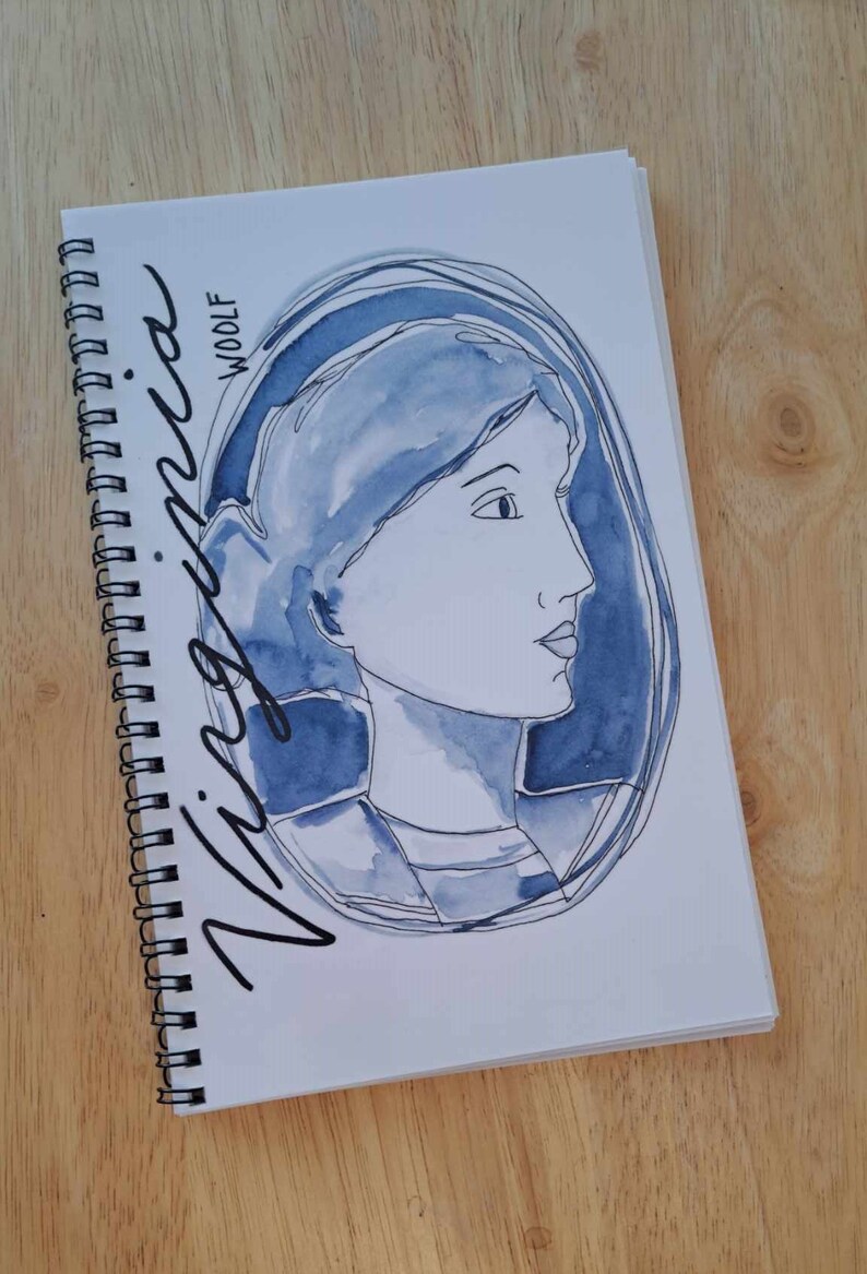 May include: A blue watercolour illustration of a person's face in a circle with the words "Virginia Woolf" written in black cursive.