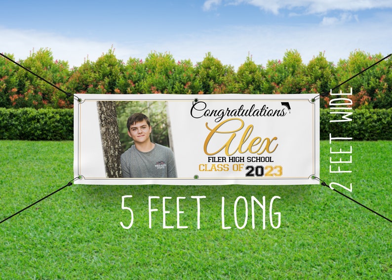 Op de afbeelding: Witte afstudeerbanner met een gouden en zwart ontwerp. De banner bevat een foto van een persoon, de tekst "Congratulations Alex", "Filer High School" en "Class of 2023". De banner is 1,5 meter lang en 0,6 meter breed.
