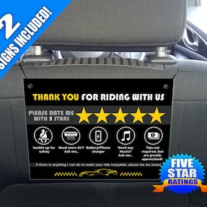 May include: Two black and yellow signs with the text "Thank you for riding with us." and "Please rate me with 5 stars." with five yellow stars below the text. The signs also have icons for safety, air conditioning, phone charger, music, and tips.