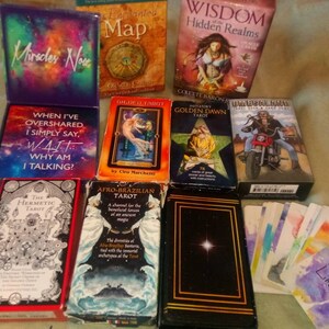 以下が含まれることがあります： 「隠された領域の知恵」、「ゴールデン・ドーン・タロット」、「ギルデッド・タロット」、「アフロ・ブラジリアン・タロット」、「ヘルメティック・タロット」、「ユニバーサル・ライダー・ウェイト・タロット・デッキ」、「私が話しすぎるときは、私は単に言う...W.A.I.T. なぜ私は話しているのか？ 」と「今すぐ奇跡」を含む、タロットとオラクルデッキのコレクションです。