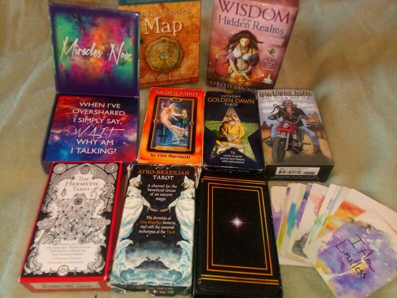 以下が含まれることがあります： 「隠された領域の知恵」、「ゴールデン・ドーン・タロット」、「ギルデッド・タロット」、「アフロ・ブラジリアン・タロット」、「ヘルメティック・タロット」、「ユニバーサル・ライダー・ウェイト・タロット・デッキ」、「私が話しすぎるときは、私は単に言う...W.A.I.T. なぜ私は話しているのか？ 」と「今すぐ奇跡」を含む、タロットとオラクルデッキのコレクションです。