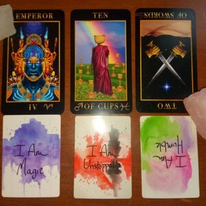 以下が含まれることがあります： タロットカードリーディングで、皇帝、カップの10、ソードの2、そして「私は魔法だ」「私は止められない」と書かれた2枚のアファメーションカードを含む5枚のカードを使用しています。
