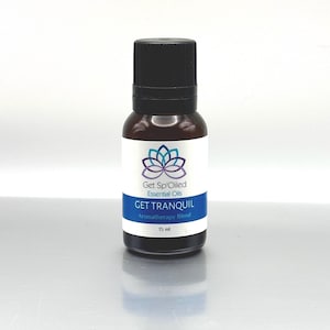 May include: A brown glass bottle with a black cap containing Get Spoiled Essential Oils "Get Tranquil" aromatherapy blend. The bottle is labeled with a purple and blue lotus flower design and the text "Get Spoiled Essential Oils" and "Get Tranquil Aromatherapy Blend". The bottle contains 15 ml of oil.