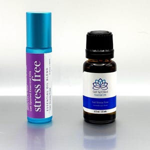 May include: Two bottles of essential oil, one blue and one brown, both labeled "Get Stress Free" with the brand name "Get Sp'Oiled Essential Oils". The blue bottle is a roll-on and the brown bottle is a 1/2 ounce bottle.