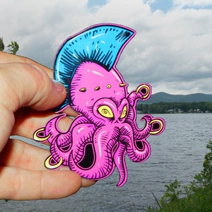 May include: A pink octopus with a blue mohawk and yellow rings on its tentacles. The octopus is drawn in a cartoon style and has a mischievous expression.