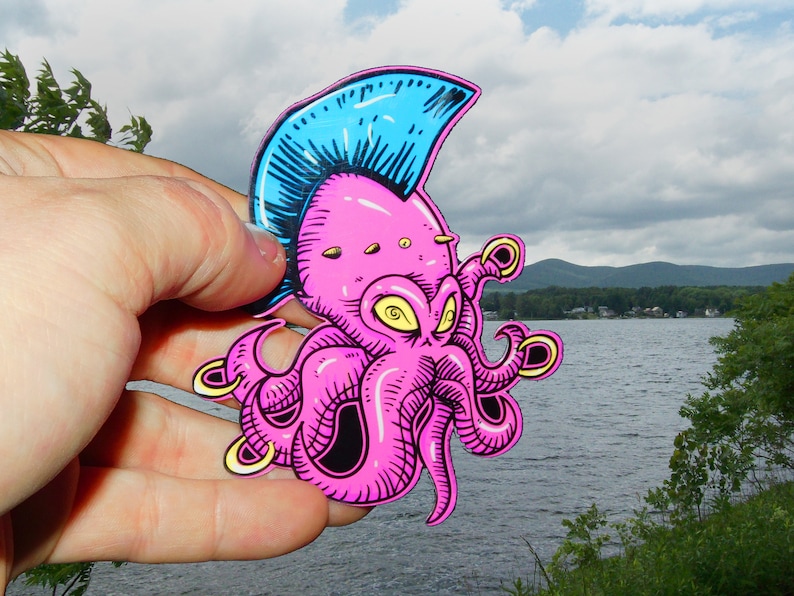May include: A pink octopus with a blue mohawk and yellow rings on its tentacles. The octopus is drawn in a cartoon style and has a mischievous expression.