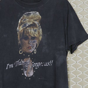 Puede incluir: Una camiseta negra con una imagen descolorida de una mujer con cabello rubio y el texto "I'm This Gorgeous!!" impreso en la parte delantera.