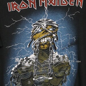 Pu&ograve; includere: Maglietta nera con una grafica di Eddie, la mascotte della band heavy metal Iron Maiden, bendato, incatenato ed elettrificato. Il nome della band &egrave; stampato in lettere rosse nella parte superiore della maglietta. Il testo "The Church of Satin.com" &egrave; stampato nella parte inferiore della maglietta.