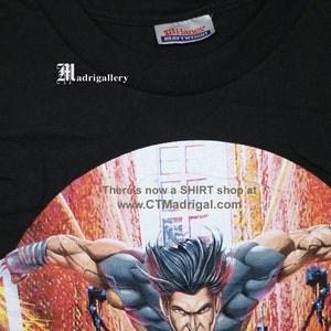 Puede incluir: Camiseta negra con un gr&aacute;fico de Wolverine, un superh&eacute;roe de c&oacute;mics, en una pose din&aacute;mica. La camiseta est&aacute; hecha de tela Hanes de peso pesado y tiene un dise&ntilde;o circular con el texto "There's now a SHIRT shop at www.CTMadrigal.com".