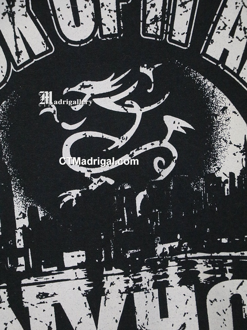 May include: Black and white graphic t-shirt with a distressed design. The shirt features a dragon with the text "Madrigal" and "CTMadrigal.com".