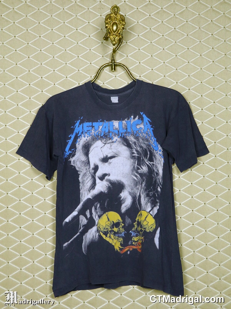 K&ouml;nnte beinhalten: Schwarzes T-Shirt mit einem Grafikdruck des Metallica-S&auml;ngers James Hetfield, der mit zwei gelben Sch&auml;delherzen singt.