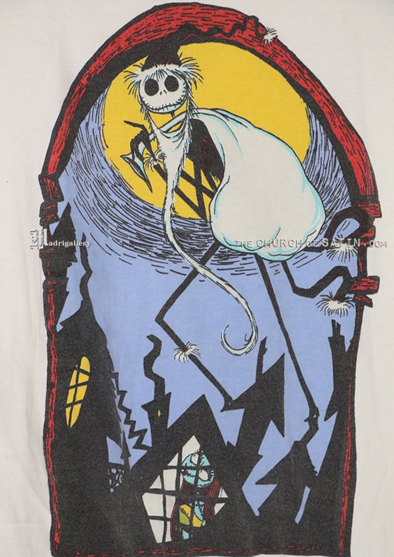 Puede incluir: Una camiseta blanca con una ilustraci&oacute;n en blanco y negro de un personaje esqueleto con una capa blanca de fantasma, de pie sobre una luna azul y amarilla. El personaje sostiene una guada&ntilde;a. La ilustraci&oacute;n est&aacute; enmarcada en un arco rojo con una silueta negra de una casa y un personaje m&aacute;s peque&ntilde;o en una ventana.