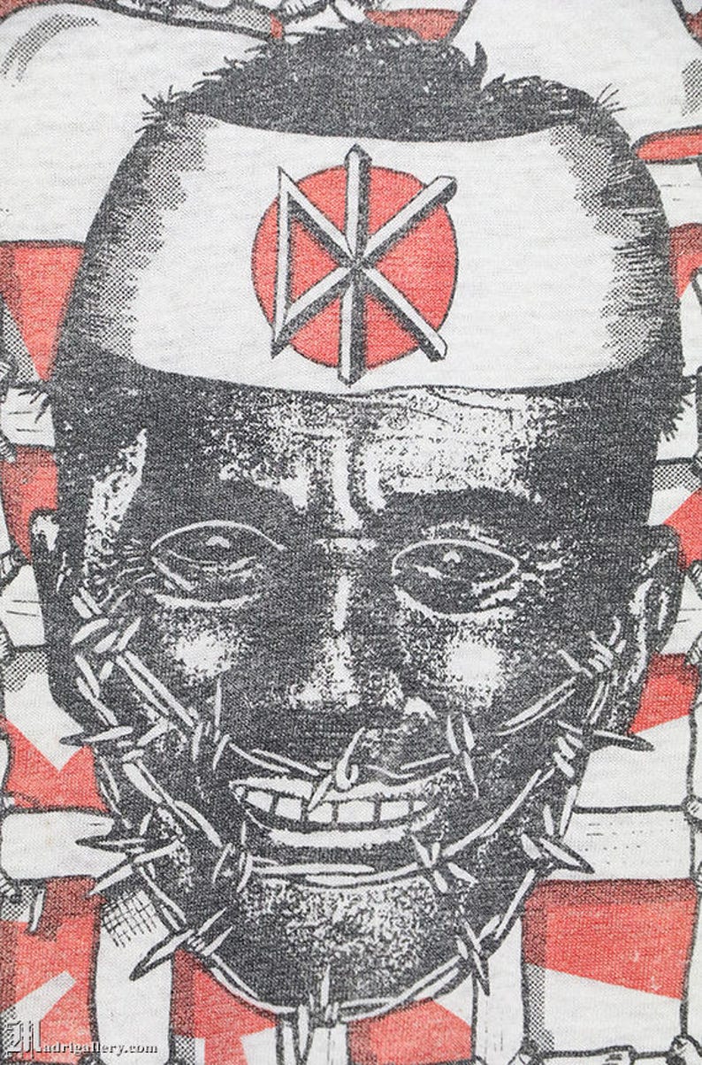 May include: A black and white illustration of a face with a barbed wire mouth. The face is wearing a white hat with a red circle and a black symbol in the center. The background is red and white.