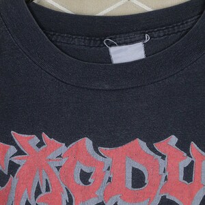 May include: Black t-shirt with a red, white, and blue graphic print of the word "Exodus".
