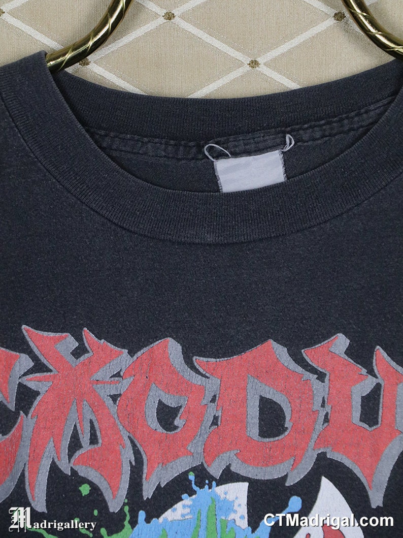 May include: Black t-shirt with a red, white, and blue graphic print of the word "Exodus".