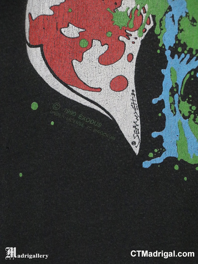 May include: Black t-shirt with a red, white, and green graphic print of a heart with a skull inside. The text "1989 Exodus" is printed on the bottom of the heart.