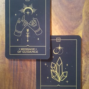 May include: Two black cards with gold accents and illustrations. The top card has the number 36 and the text "Message of Guidance". The bottom card has the number 35 and the text "Message of Peace".