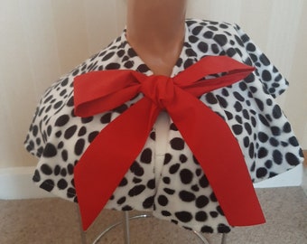 May include: A white and black dalmatian print fabric collar with a large red bow. The collar is made of soft, plush fabric and is perfect for adding a touch of whimsy to any outfit.