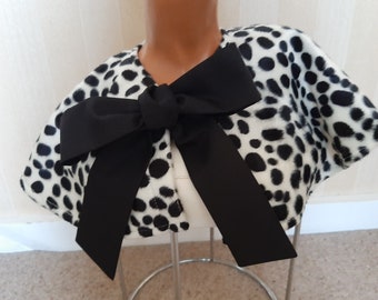 May include: A white and black dalmatian print cape with a black satin bow.