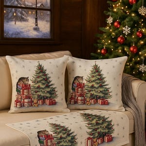 Könnte beinhalten: Dekorative Kissen und Tischläufer zum Thema Weihnachten. Die Kissen und der Läufer zeigen ein festliches Design mit einem Weihnachtsbaum, Geschenken und einer Katze. Die Farbpalette umfasst Grün, Rot und Beige.