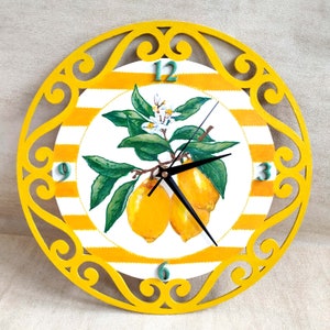 May include: Yellow and white striped clock face with a lemon tree design and black clock hands. The clock face is surrounded by a yellow, decorative, wooden frame.