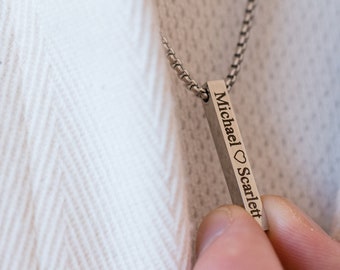 Könnte beinhalten: Eine silberne Kettenkette mit einem vertikalen Bar-Anhänger, der mit dem Text "Michael ♥ Scarlett" graviert ist.