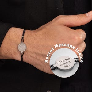 Peut inclure: Un bracelet en cordon noir avec un charme de boussole argenté. Le charme a un message secret à l'intérieur qui dit "Je serais perdu sans toi".