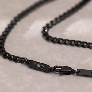 Peut inclure: Un collier de chaîne noir avec une étiquette en métal noir qui dit "D♡G".