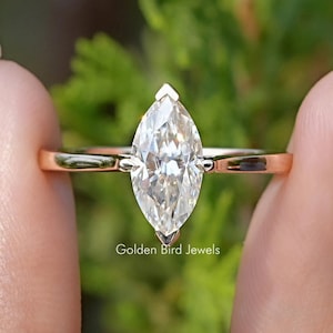 Op de afbeelding: Een gouden verlovingsring met een marquise-vormige diamant.