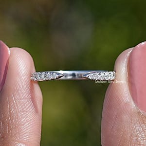 May include: A silver-toned open ring featuring two pointed ends, each encrusted with a row of small, clear, sparkling stones. The band is thin and polished, with the text Golden Bird Jewels printed in small white letters on the metal surface.