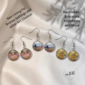 May include: A collection of round dangle earrings with various landscape art prints. The earrings have silver-colored hooks and are displayed on a white satin surface. Text on the image reads "See Listing For Bronze Settings and other Art Choices" and "Necklaces, Bracelets Keychains and More."