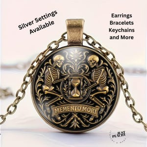 May include: A round pendant necklace with a bronze finish. The pendant features two skeletons flanking an hourglass, with the words "Memento Mori" on a banner. The chain is also bronze. Text on the image says "Silver Settings Available" and "Earrings Bracelets Keychains and More".