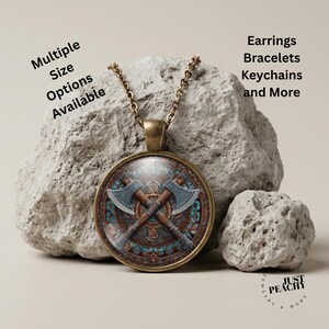 May include: A round bronze pendant necklace featuring a graphic of two crossed axes over a circular patterned background. The text Multiple Size Options Available and Earrings Bracelets Keychains and More is visible. The brand Just Peachy is present.