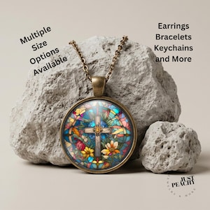 May include: A round bronze pendant necklace featuring a stained glass style cross design with colorful floral accents. Text on the image reads: Multiple Size Options Available, Earrings, Bracelets, Keychains and More, and Just Peachy.