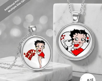 May include: Two silver-toned circular pendant necklaces featuring Betty Boop imagery. One pendant shows Betty Boop in a red dress with the text 'BETTY BOOP', while the other displays Betty Boop and Pudgy inside a heart shape with red hearts.