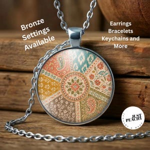 May include: A silver-toned pendant necklace featuring a circular glass cabochon with a multi-colored floral and paisley pattern. Text on the image reads: Bronze Settings Available, Earrings Bracelets Keychains and More, and Just Peachy.
