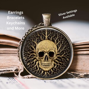 May include: A round pendant with a skull design. The skull is gold-colored with dark eye sockets, surrounded by a tree-like pattern. The pendant is on a chain. Text on the image says "Earrings, Bracelets, Keychains and More" and "Silver Settings Available".