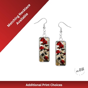 Puede incluir: Un par de pendientes rectangulares con un diseño floral de rosas rojas. Los pendientes tienen ganchos plateados y un fondo tipo mosaico. El texto "Matching Necklace Available" es visible.
