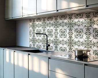 May include: A modern kitchen with white cabinets and a black faucet. The backsplash is tiled with a green and white floral pattern.