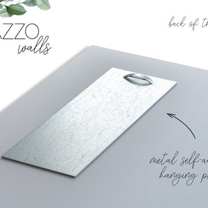 May include: The back of a print with the text "PAZZO walls" in the top left corner. The print has two metal self-adhesive hanging plates attached to the back.