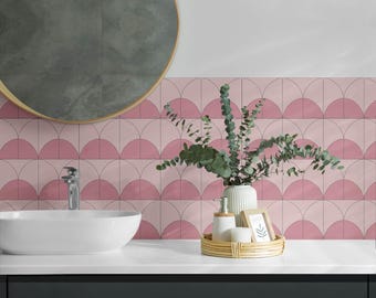 May include: A bathroom vanity with a pink and white geometric tile backsplash. A white porcelain sink with a chrome faucet is on the counter. A wooden tray with a vase of green eucalyptus, a bottle of hand soap, and a small picture frame is on the counter.