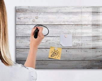 May include: A white wood-grain dry erase board with a light bulb drawing on a yellow sticky note, a white sticky note, and three silver magnets.