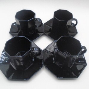 May include: Set of four black octagonal ceramic teacups and saucers. The cups and saucers have a glossy finish.