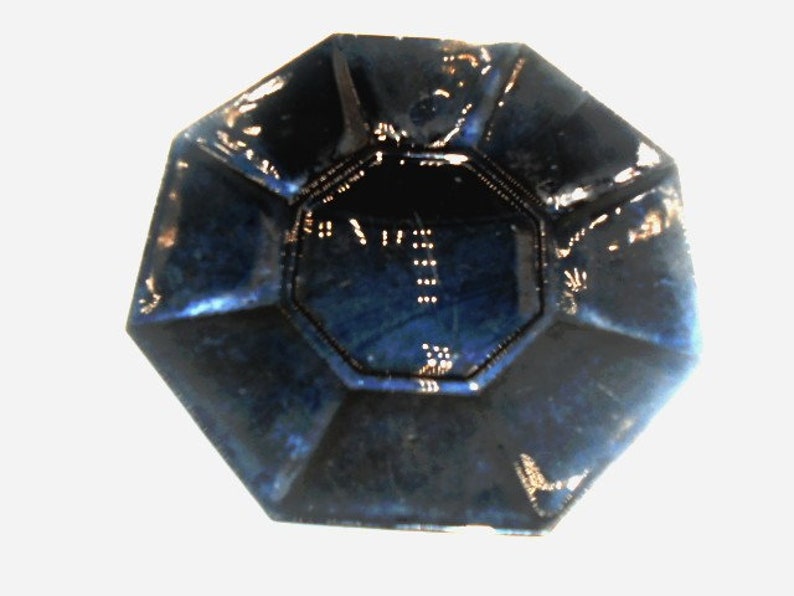 May include: A dark blue octagonal ceramic dish with a raised rim and a smooth, glossy finish.