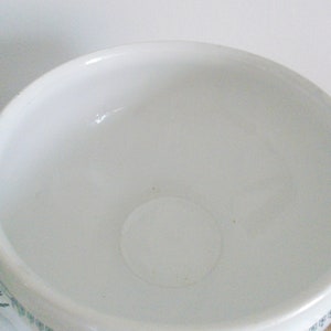 May include: White porcelain serving bowl with a wide, round opening and two handles. The bowl has a simple, elegant design and is perfect for serving salads, pasta, or other dishes.
