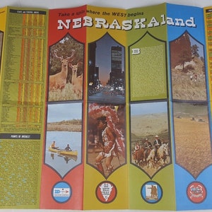 May include: A vintage, folded, paper map of Nebraska with a yellow, green, red, and blue color scheme. The map features images of a deer, a city skyline, a Native American man, and cowboys on horseback. The text "Take a spin where the WEST begins NEBRASKAland" is printed in bold, red letters at the top of the map.