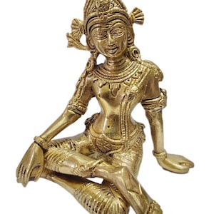 Könnte beinhalten: Eine goldfarbene Messingstatue einer sitzenden Gottheit mit aufwendigen Details und einem kronenartigen Kopfschmuck.