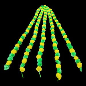 May include: Five strands of yellow and green artificial flower garland. Each strand is made of small, round pom-poms.
