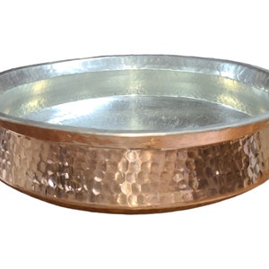 May include: A hammered copper serving bowl with a silver interior. The bowl has a rounded shape and a wide rim.