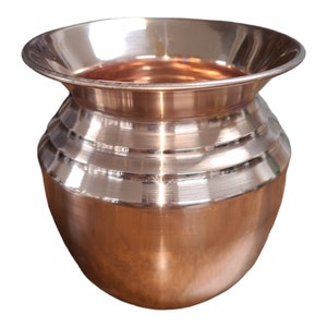 May include: A polished copper pot with a rounded body and a flared rim. The pot has a smooth, shiny finish and is ideal for traditional ceremonies or decorative purposes.